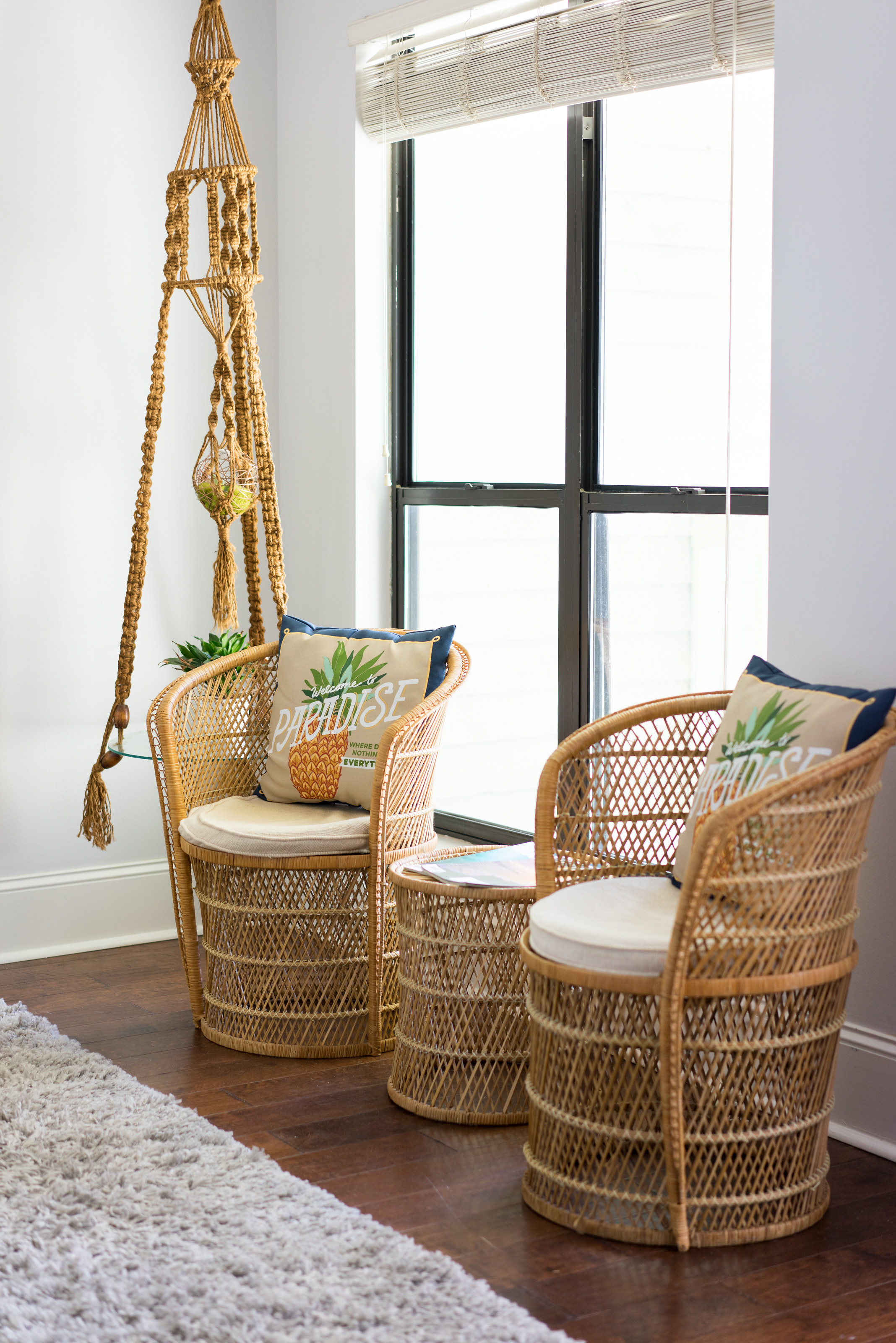 House Tour: Two rattan chairs with decorative pillows that say Welcome to Paradise
