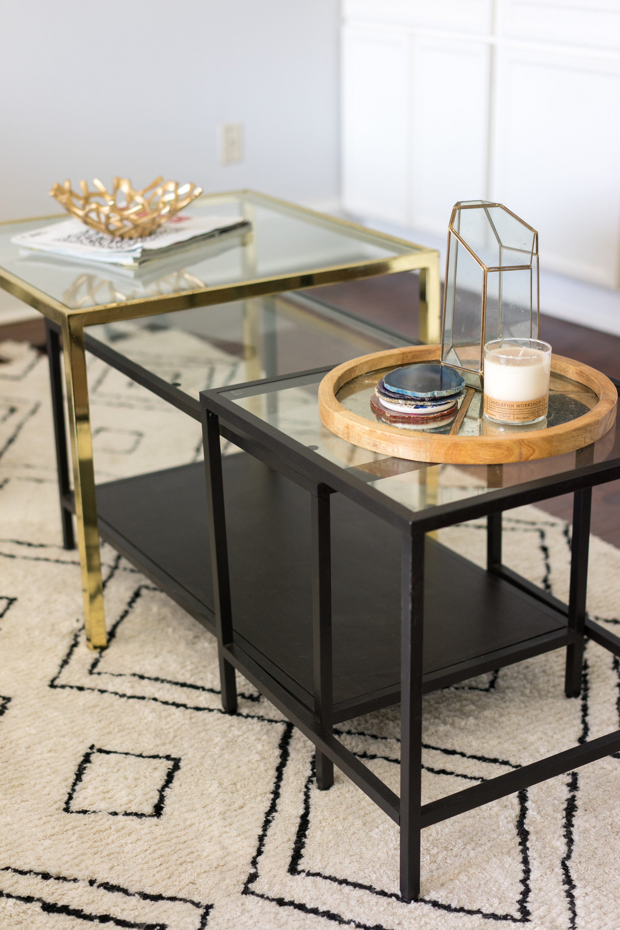 House Tour: A gold and black glass coffee table with coasters and a candle