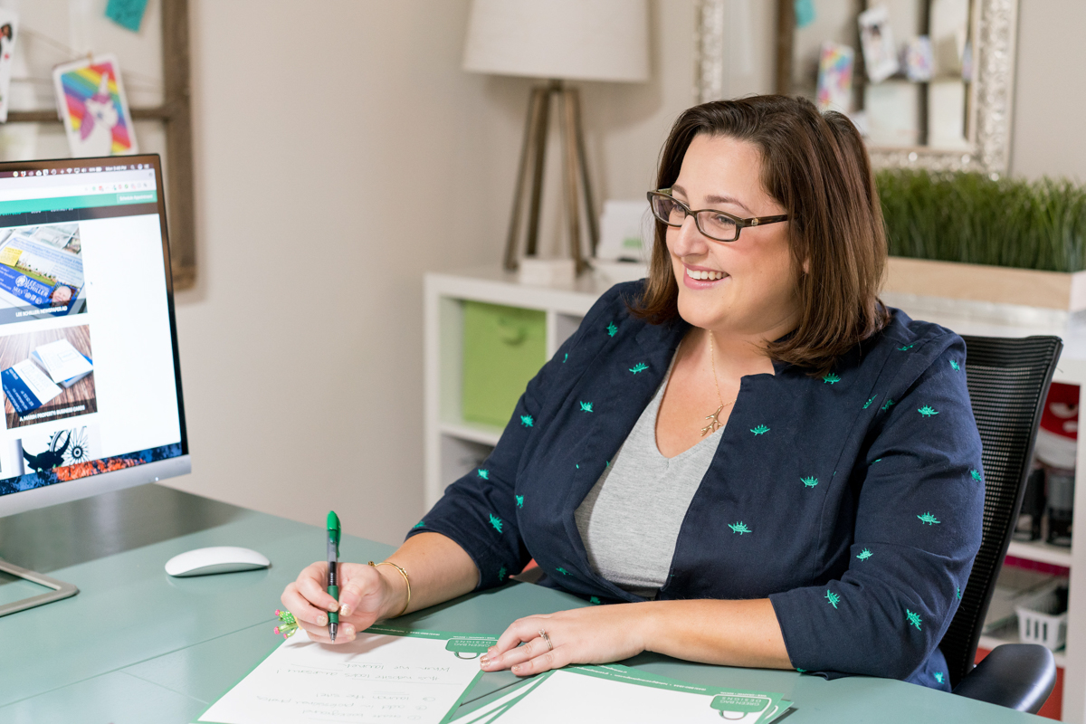 Branding photos for woman entrepreneur at her desk talking with a client