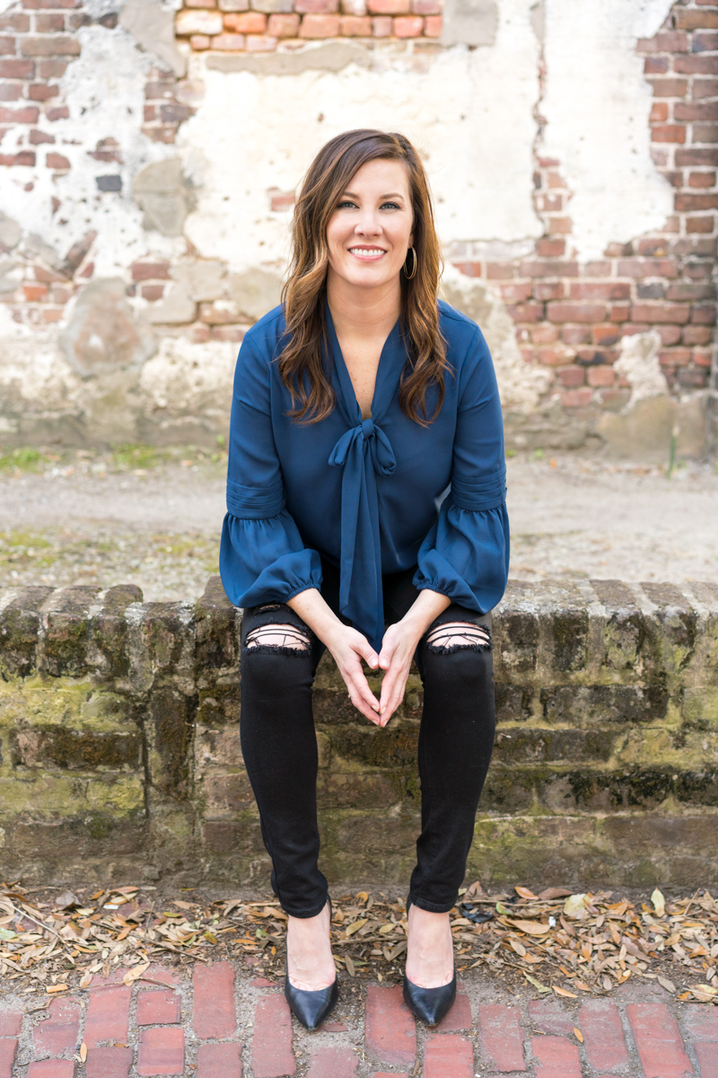 Portrait of a woman entrepreneur sitting on a brick wall