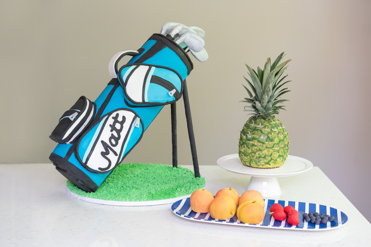 3D cakes including a golf bag, pineapple, and various fruits