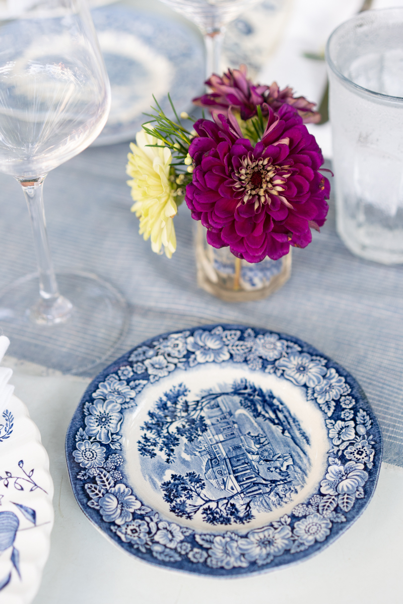 Place setting with a blue and white bread plate and flowers