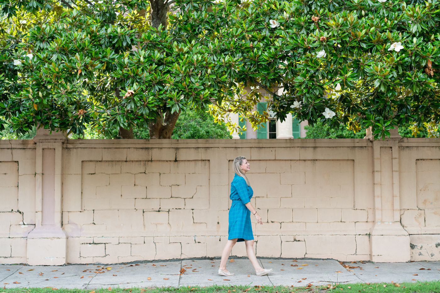 Woman wearing blue vintage dress walking along a street in Charleston, South Carolina