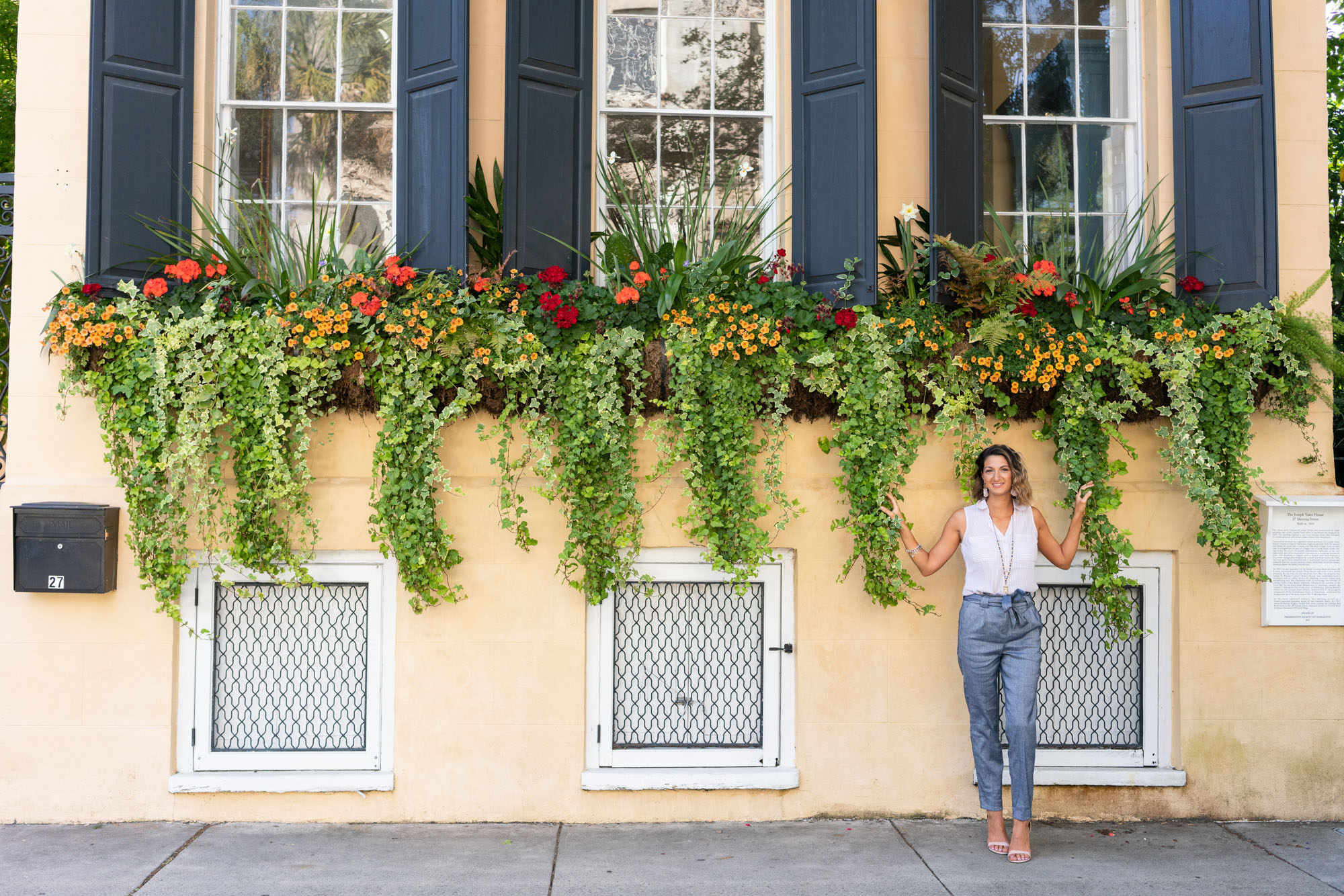 Woman standing under window boxes in Charleston, SC