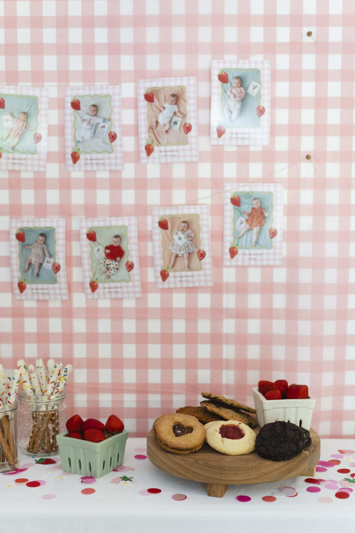 Close up of baby photos and desserts on the table below. 