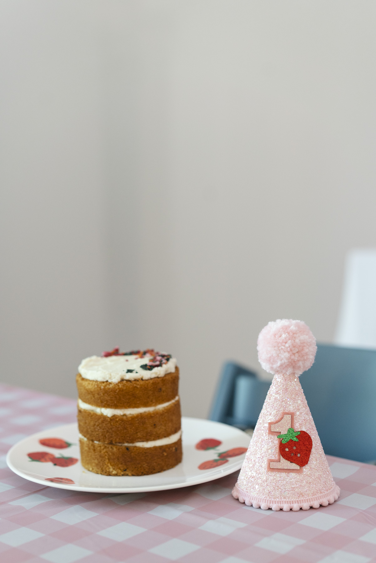 Close up photo of smash cake and birthday hat sitting on the table. 