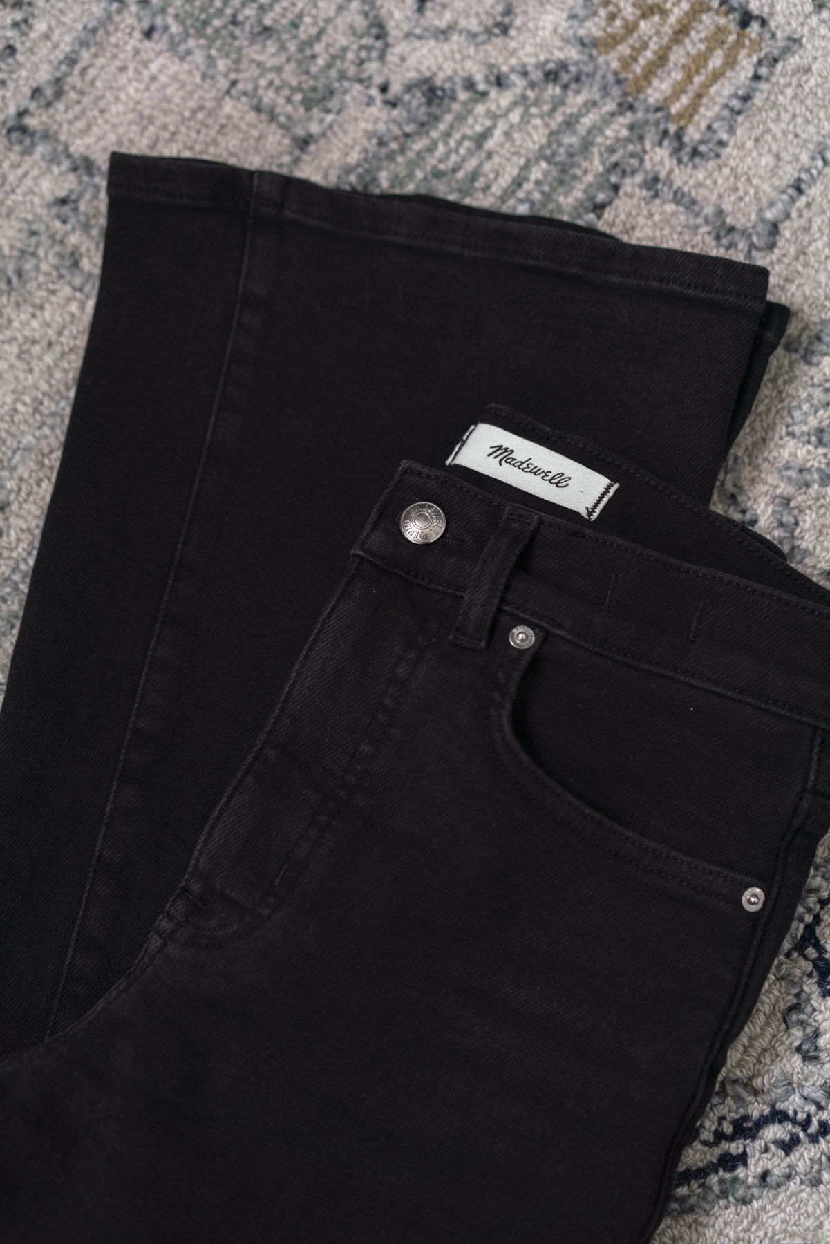 Flat view of a pair of folded black jeans.