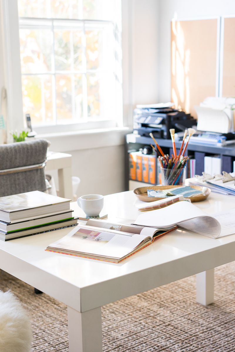 Interior Designer's white desk with coffee table inspiration books and paint brushes