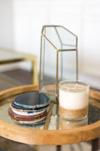 A candle, geode coasters, and geometric vase