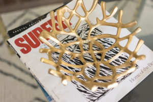 A gold coral decorative bowl on top of Surfer magazine
