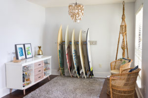 Modern, midcentury living room with a bar cart, surfboards, and sitting area