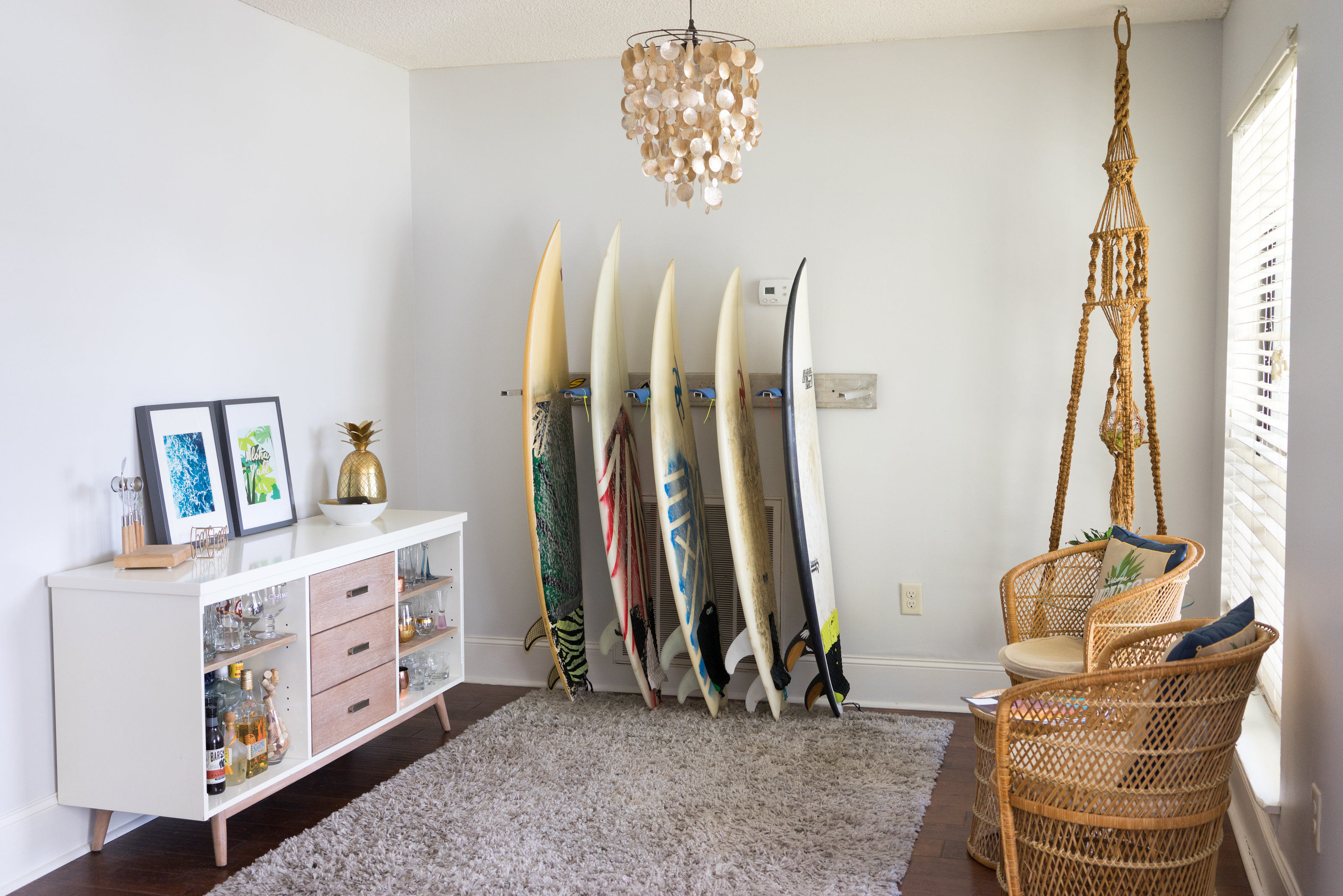 House Tour: Modern, midcentury living room with a bar cart, surfboards, and sitting area