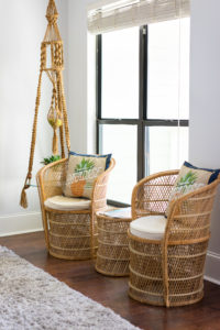 Two rattan chairs with decorative pillows that say Welcome to Paradise