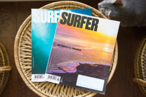 Two issues of Surfer magazine on a side table
