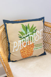 A decorative pillow that says Welcome to Paradise
