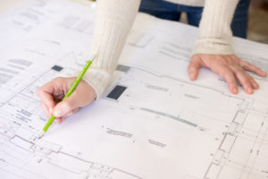 Close up photo of a woman making notes on an interior design layout plan