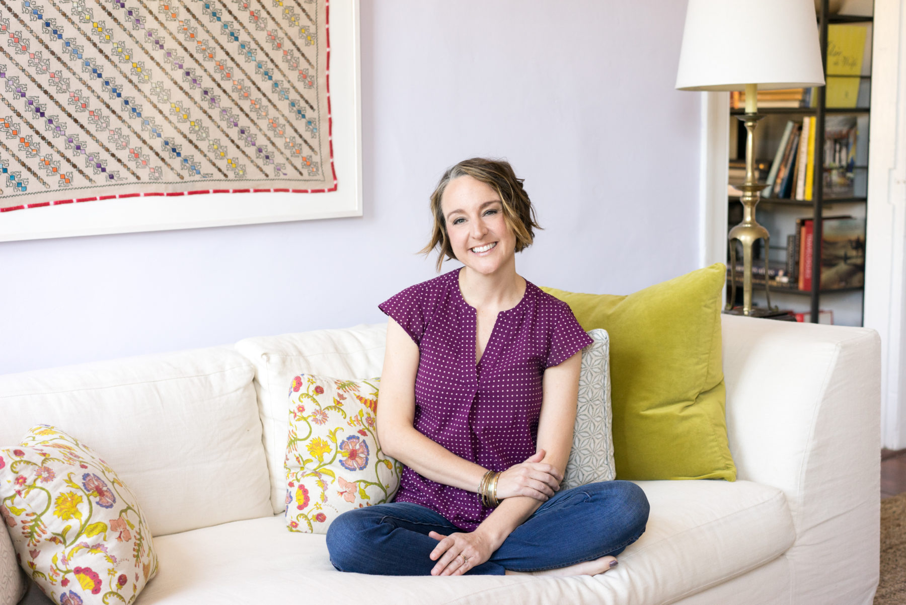 A lifestyle headshot of an interior designer sitting on a couch