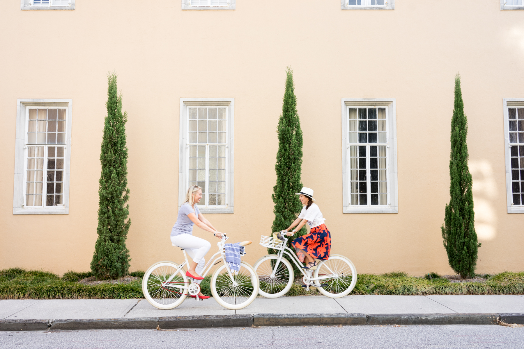 Two women riding white bikes in Charleston, South Carolina