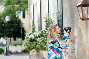 Woman taking photograph of a house in Charleston, South Carolina