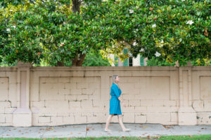 Woman wearing blue vintage dress walking along a street in Charleston, South Carolina