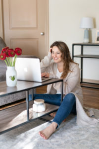 Branding photo of a woman sitting by her coffee table with her computer