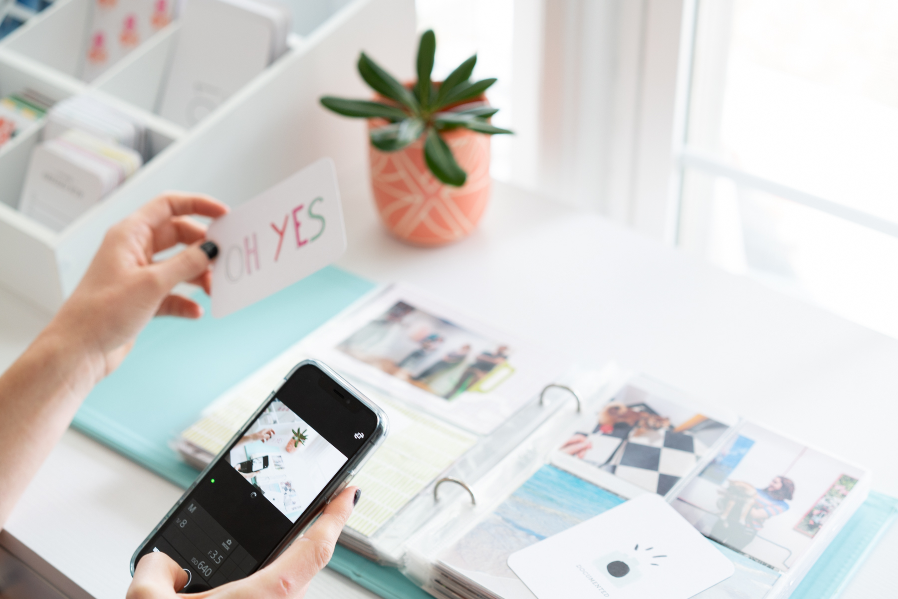 Girl taking a photo of her scrapbook with an iPhone