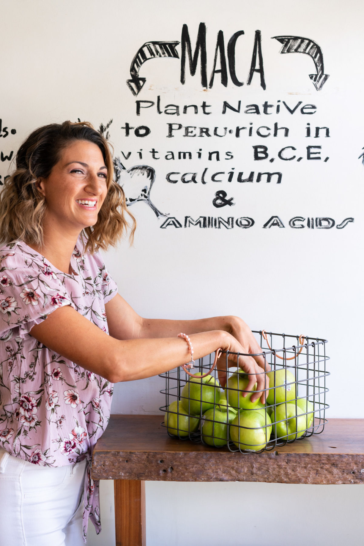 Woman choosing apples out of a metal basket