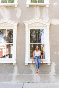 Woman sitting in a window of a historic house in Charleston, SC