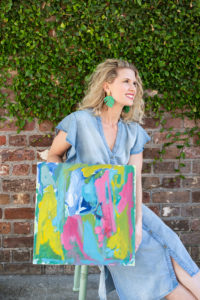 Charleston artist Fallon Peper holding one of her abstract paintings