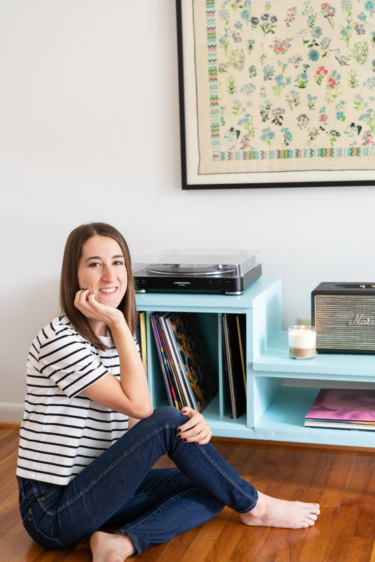 Photographer Abby Murphy sitting on the floor of her office by her record player