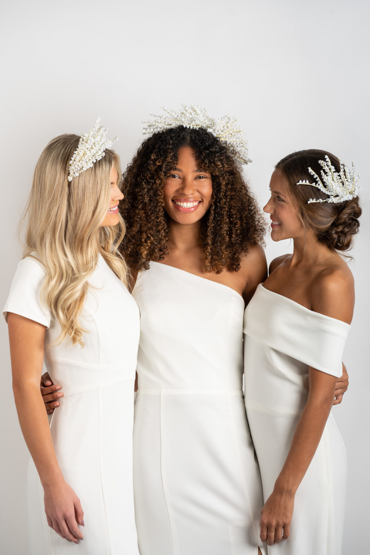 Fashion shoot with three models wearing Mariee Lace Veil headpieces and white bridesmaids dresses