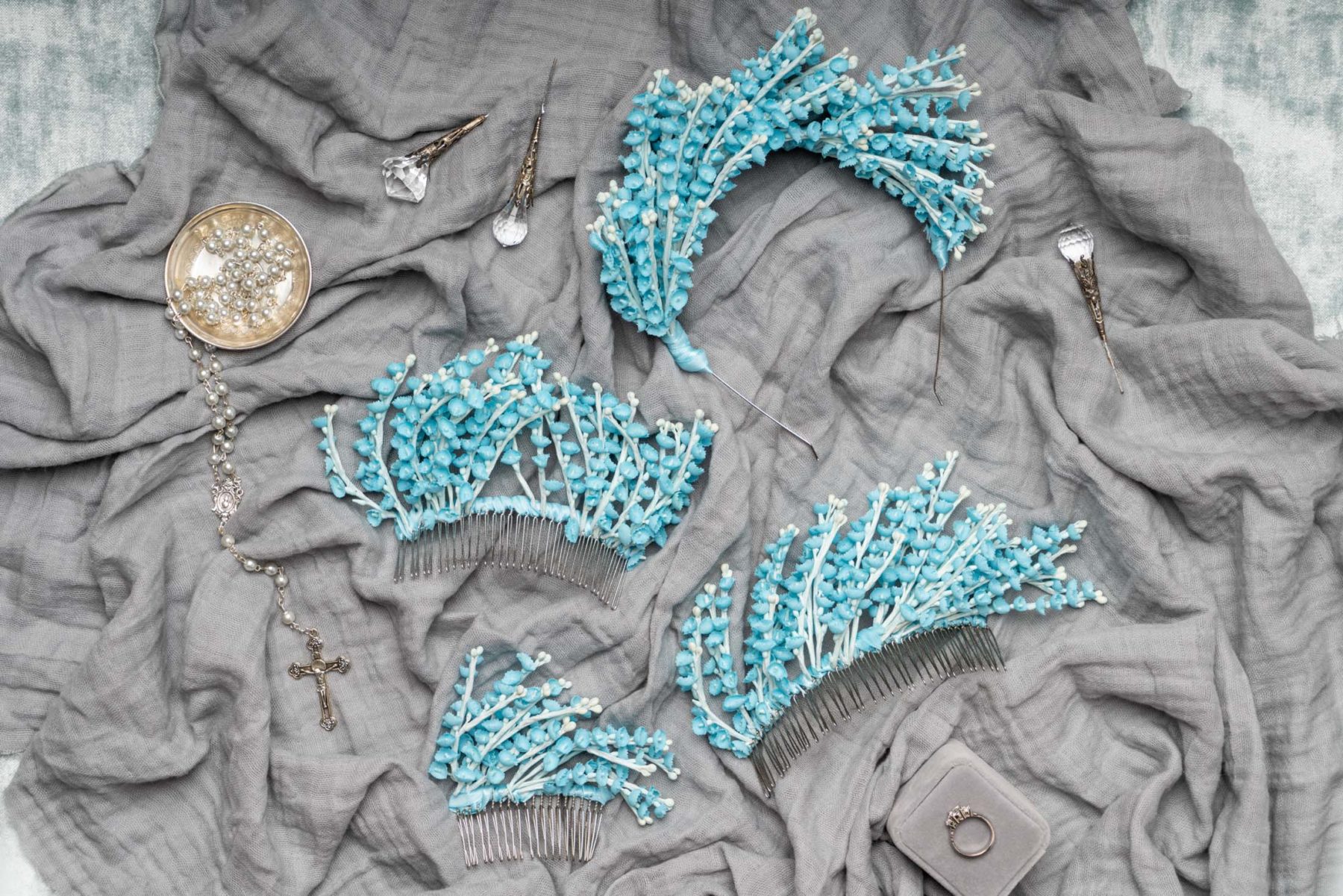 Flat lay of blue Mariee Lace Veil custom wedding headbands on blue fabric