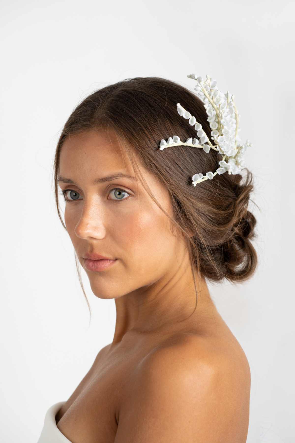 Model on a white background wearing a custom wedding headpiece by Mariee Lace Veils
