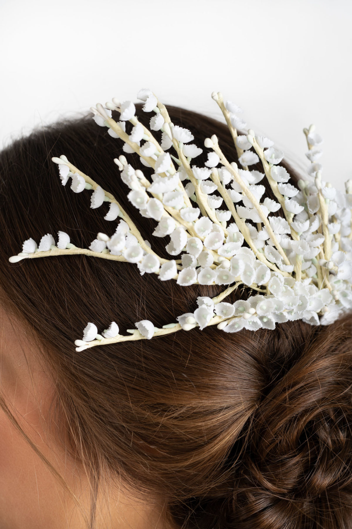 Detail shot of a white wedding headpiece by Mariee Lace Veils