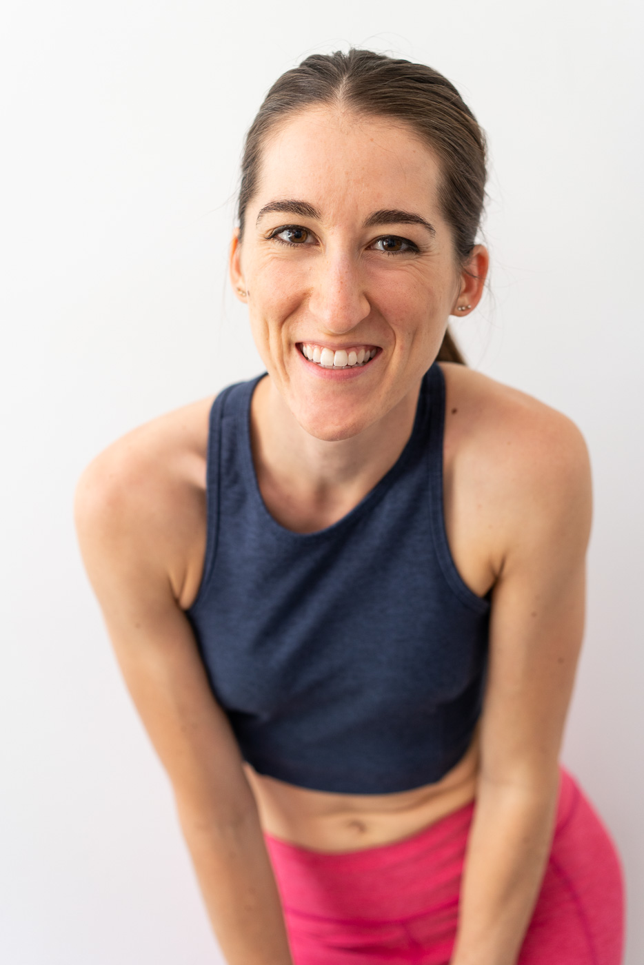 Woman in workout clothing leaning forward and smiling