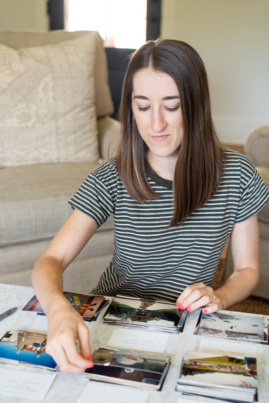 Woman organizing old family photos into categorized piles