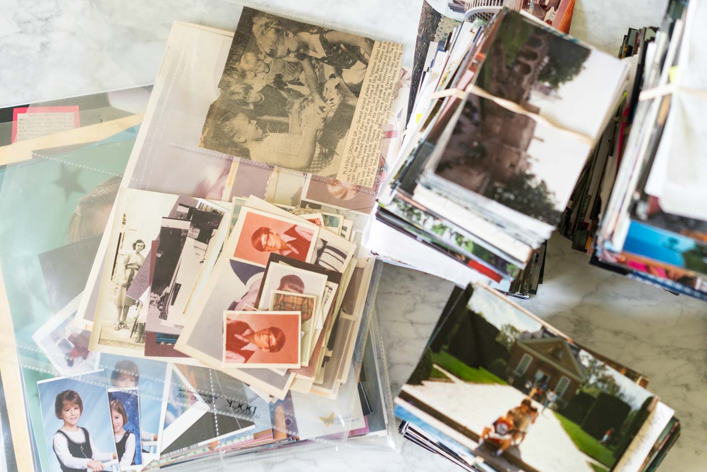Piles of 4x6" photo prints and old school pictures in plastic photo sleeves