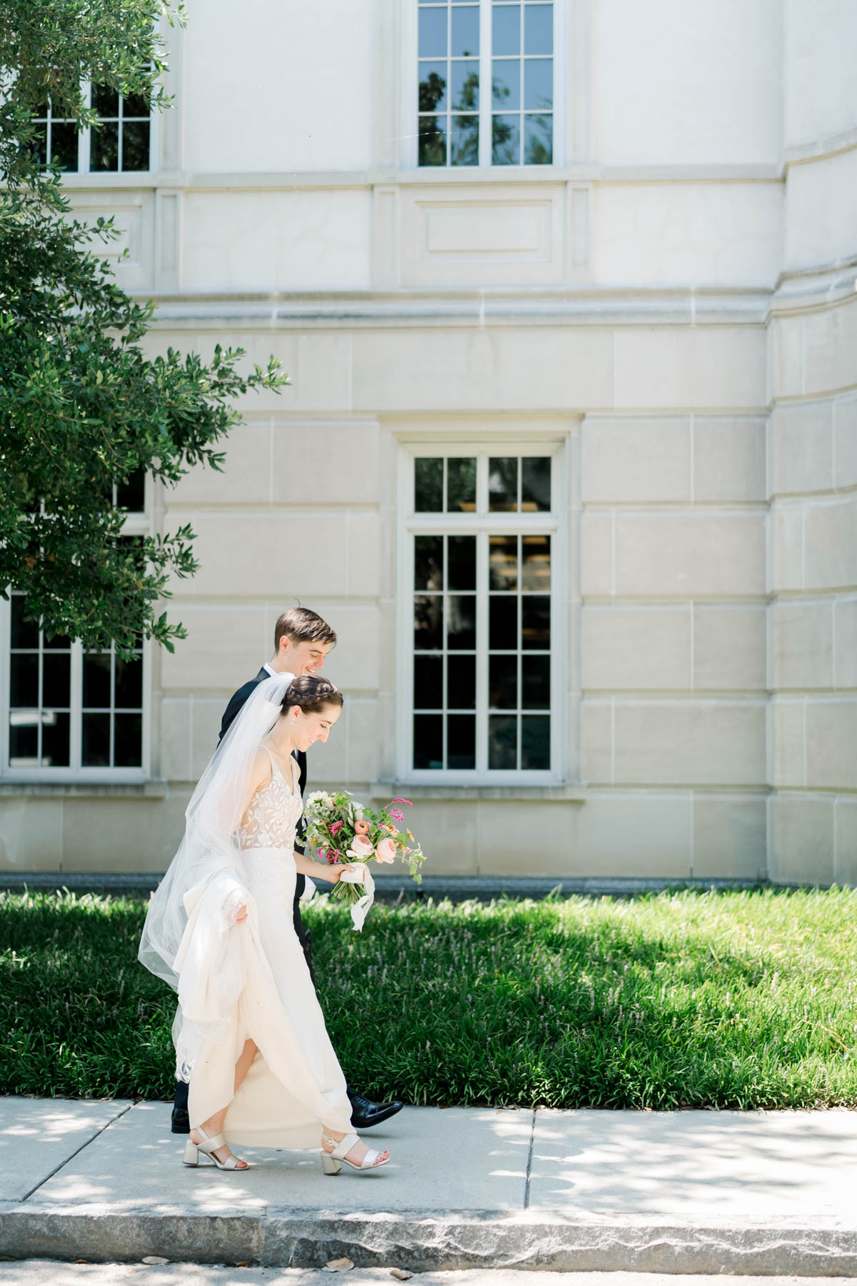 A bride and groom walking by the Gaillard Center in Charleston, SC 
