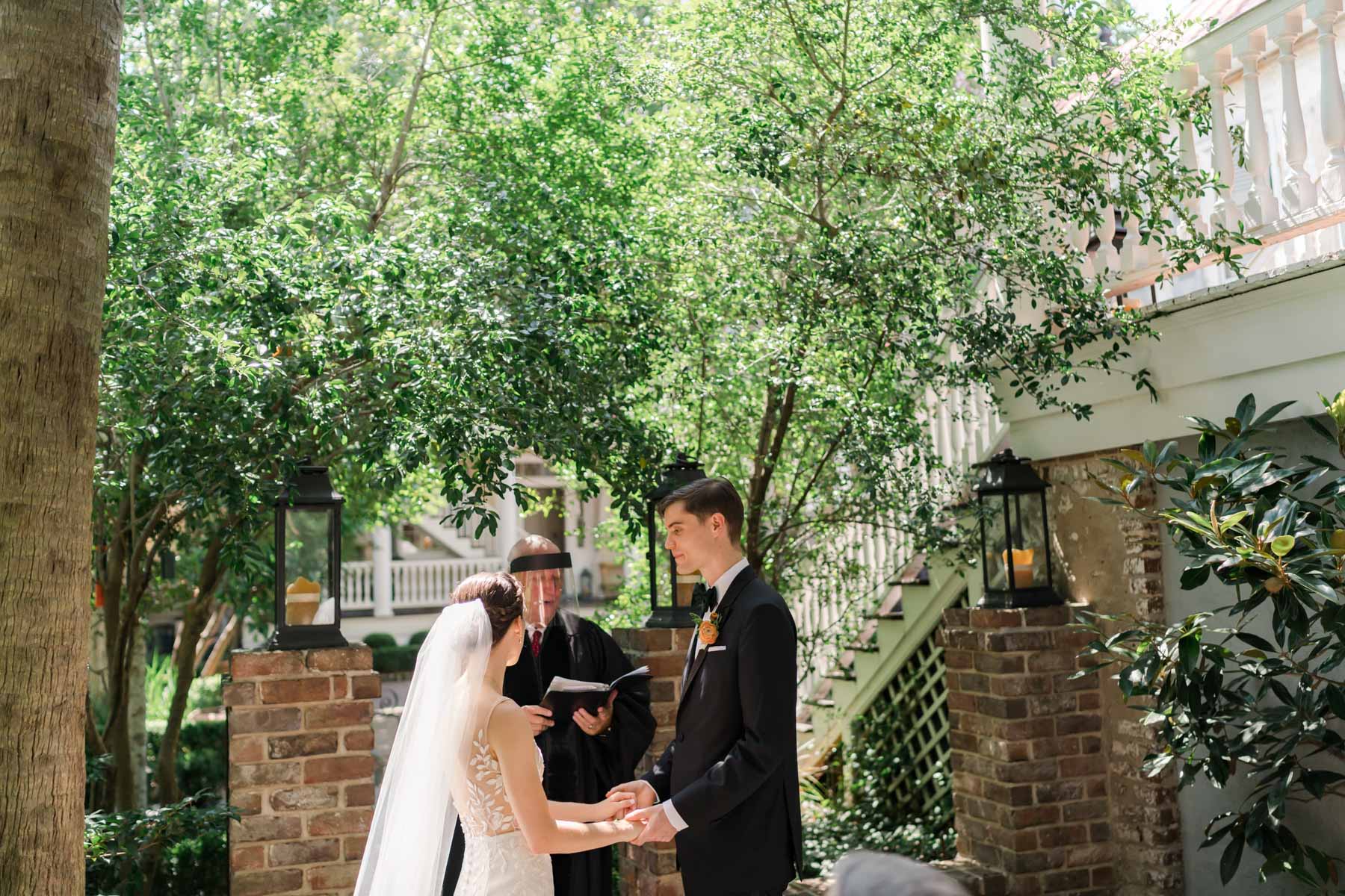 A bride and groom holding hands during their intimate Charleston wedding ceremony at Zero George hotel