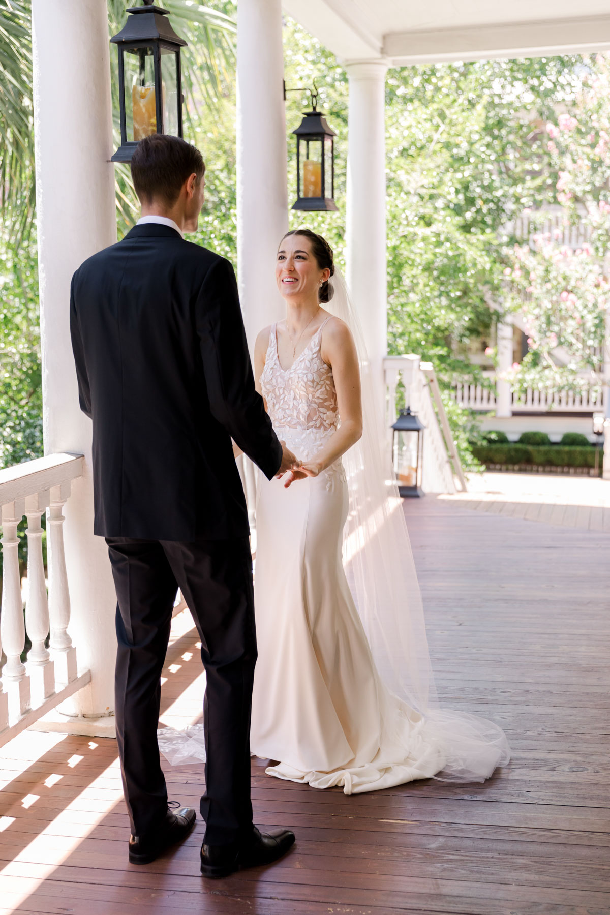 A bride and groom hold hands during their first look at Zero George hotel in Charleston, SC