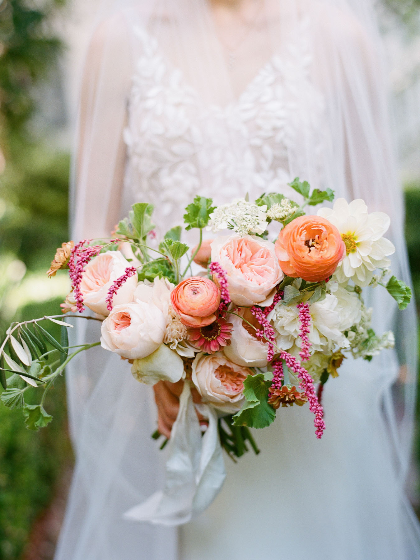 Brightly colored bridal bouquet with whites, corals, soft pinks, and greens.