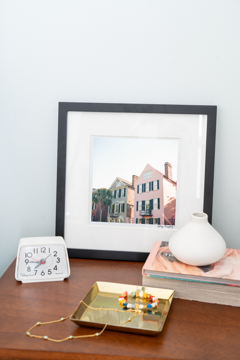 A photograph of two colorful homes on Meeting Street in Charleston, South Carolina leaning on a bedside table