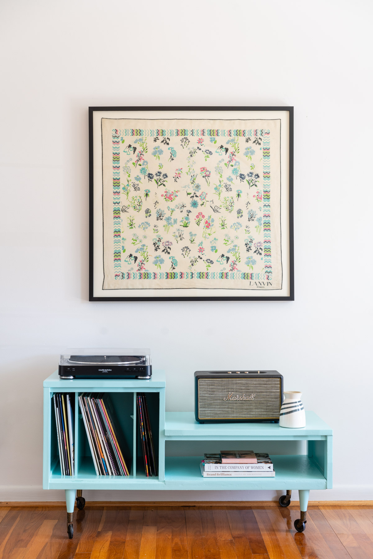 A vintage Lanvin silk scarf hanging above a blue record player table. 