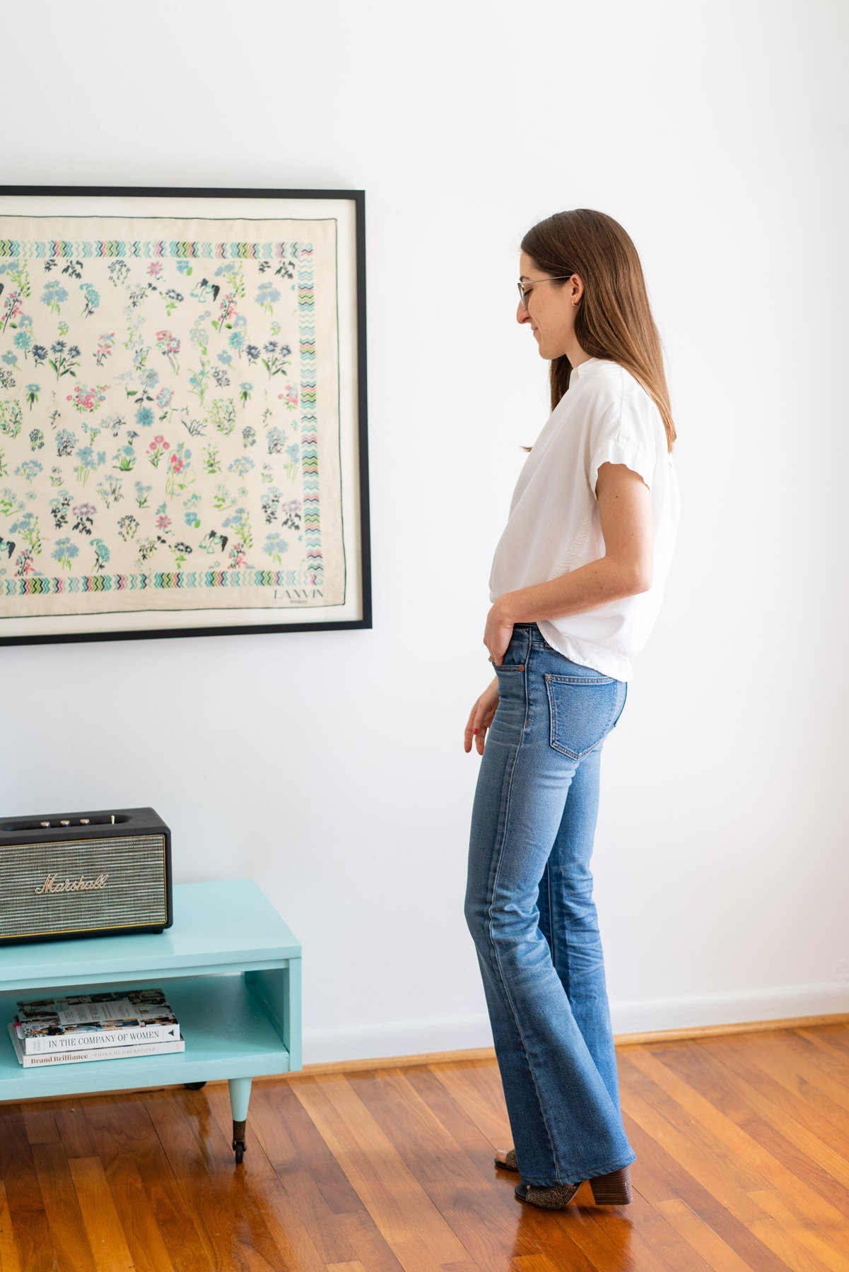 Woman modeling Madewell's Flare jeans with a white button up shirt tied at the waist