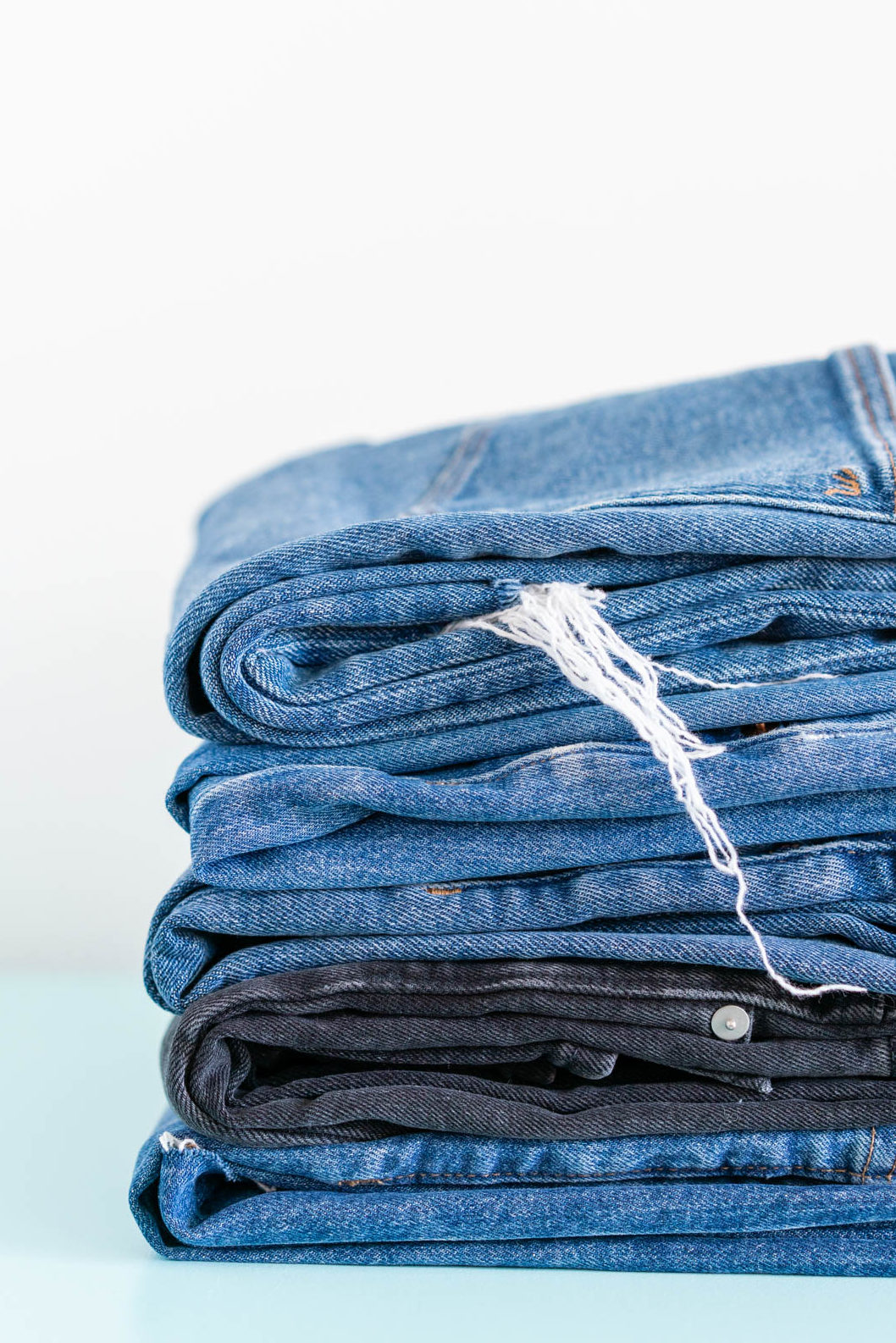 A pile of 5 pairs of Madewell denim jeans
