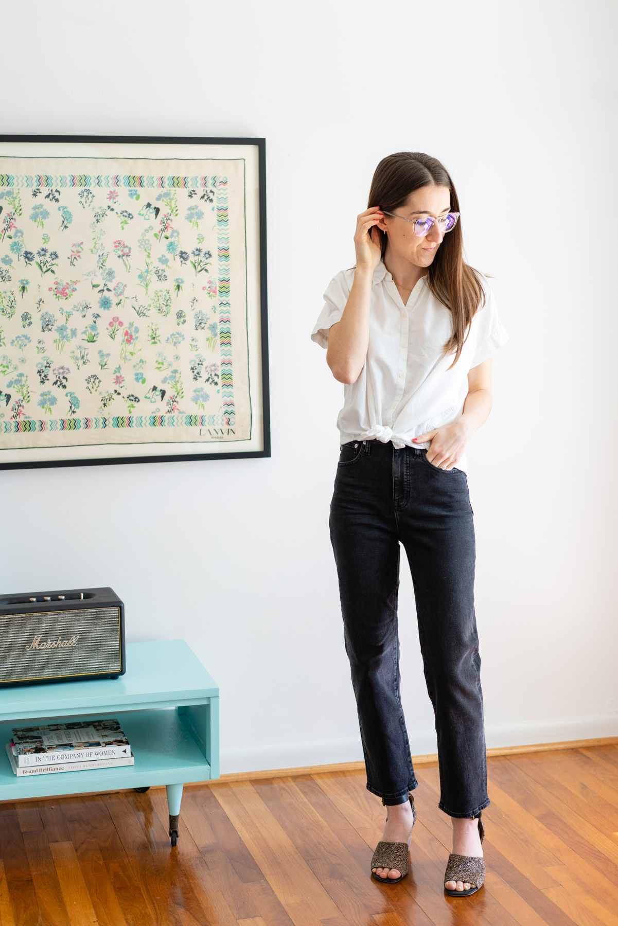 Woman modeling Madewell's Classic Straight jeans in a black wash Madewell jeans review with a white button up shirt tied at the waist
