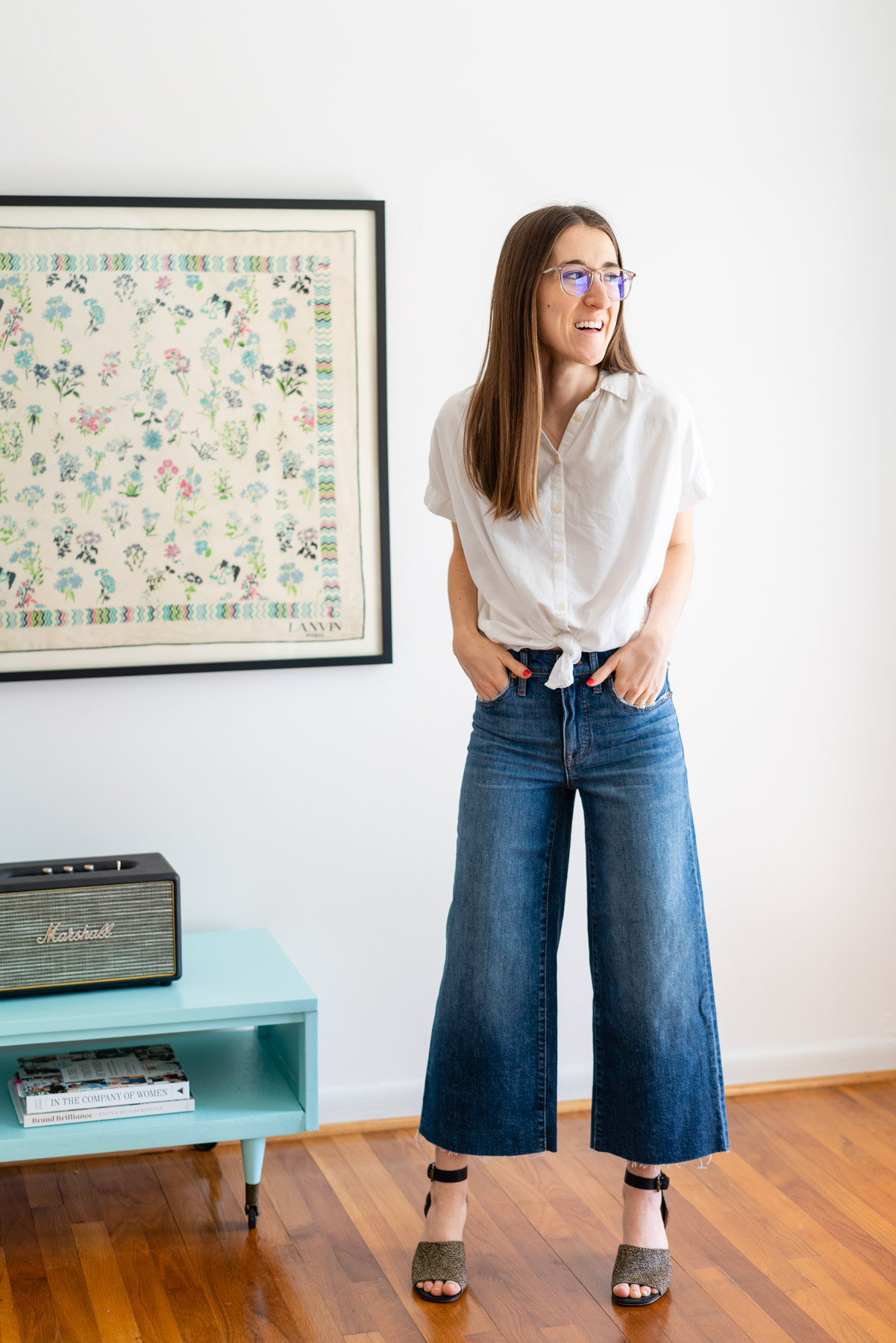 Woman modeling Madewell's Wide Leg jeans for a Madewell jeans review with a white button up shirt tied at the waist