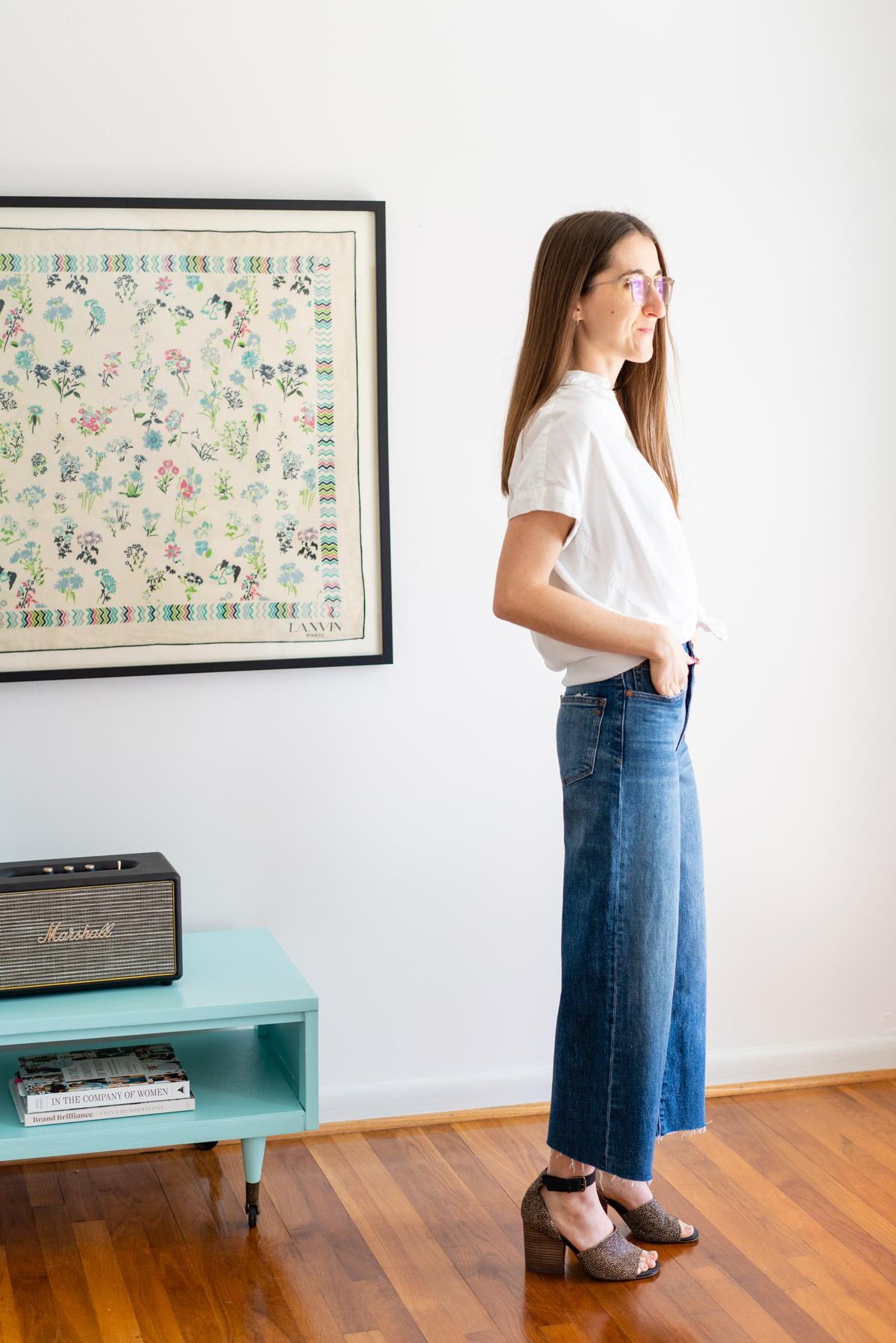 Woman modeling Madewell's Wide Leg jeans with a white button up shirt tied at the waist