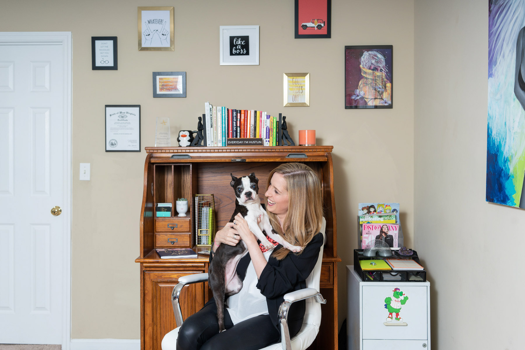 Marketing brand photo of a marketing expert sitting at her desk and holding her dog